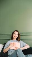 Joyful Middle-Aged Woman Holding a Book Close. Smiling Lady Embracing a Book with Cheerful Expression. Happiness and Literature Connection. Middle-Aged Woman Grasping a Book photo