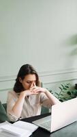 Fatigued Young Woman, Overworked and Dejected, Gazing at Computer Screen in Distress. Overwhelmed Young Woman Struggling at Computer Desk, Battling Overexertion and Weariness photo