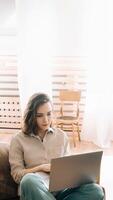 Productive Home Workspace. Woman Typing on Laptop in Living Room. Home Office Vibes. Serious Woman Typing on Laptop in Living Room. photo