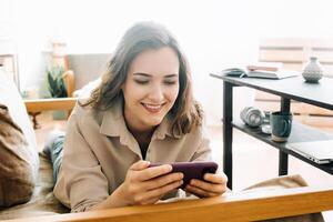 Joyful Woman Engaging with Smartphone. Reading Messages, Socializing on Social Media, and Playing Mobile Games. Happy Young Female Embracing Digital Interaction and Entertainment on Mobile Device photo