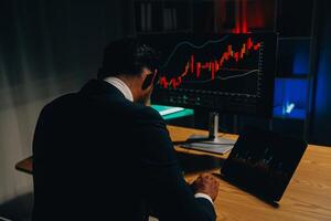 Thoughtful focused successful caucasian male stock investor, broker, financial adviser, sits at work desk, looks at computer, pensively analyze risks and prospects, rise or fall of cryptocurrency coin photo