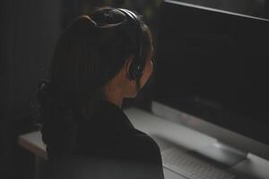 Young woman working in call centre, surrounded by colleagues photo