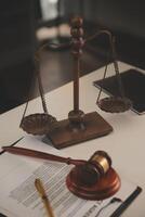 image of judge's hammer, scales lady of justice, law book, laptop computer and contract documents with pen concept of law and justice. photo