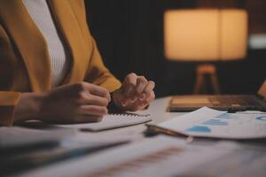 Business woman using calculator for do math finance on wooden desk in office and business working background, tax, accounting, statistics and analytic research concept photo