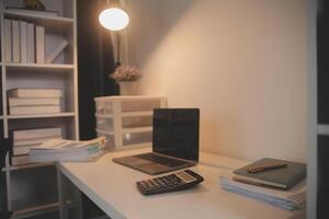 Laptop and paperwork on conference table photo