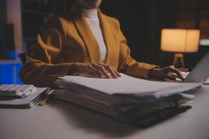 Business woman using calculator for do math finance on wooden desk in office and business working background, tax, accounting, statistics and analytic research concept photo