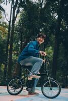 Young handsome bearded man taking a break while travelling the city with his bicycle using his digital tablet looking away thoughtfully photo