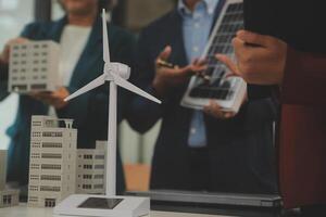 Close-up at tablet, Engineers pointing at tablet with their hands. To jointly design the use of renewable energy with wind and solar energy. Concept of using renewable energy. photo