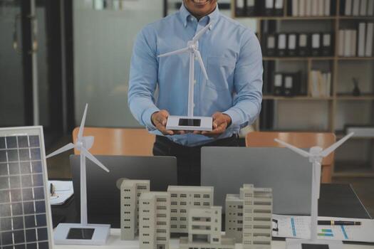 Close-up at tablet, Engineers pointing at tablet with their hands. To jointly design the use of renewable energy with wind and solar energy. Concept of using renewable energy. photo