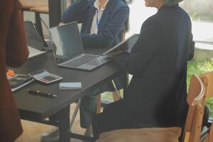 Business team meeting working with new startup project, discussion and analysis data the charts and graphs. Digital tablet, calculator, laptop computer using, Business finance and accounting concept. photo