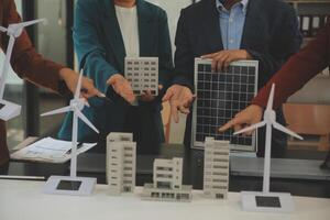 Close-up at tablet, Engineers pointing at tablet with their hands. To jointly design the use of renewable energy with wind and solar energy. Concept of using renewable energy. photo