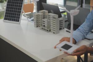 Close-up at tablet, Engineers pointing at tablet with their hands. To jointly design the use of renewable energy with wind and solar energy. Concept of using renewable energy. photo