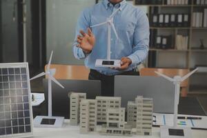 Close-up at tablet, Engineers pointing at tablet with their hands. To jointly design the use of renewable energy with wind and solar energy. Concept of using renewable energy. photo