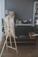 Cropped image of female artist standing in front of an easel and dipping brush into color palette photo