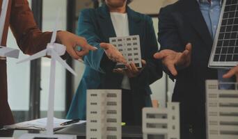 de cerca a tableta, ingenieros señalando a tableta con su manos. a conjuntamente diseño el utilizar de renovable energía con viento y solar energía. concepto de utilizando renovable energía. foto