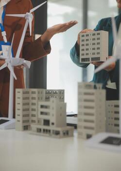Close-up at tablet, Engineers pointing at tablet with their hands. To jointly design the use of renewable energy with wind and solar energy. Concept of using renewable energy. photo