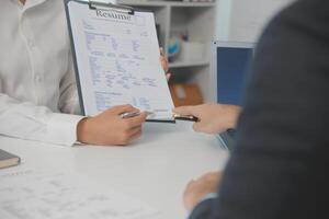 cerca arriba ver de trabajo entrevista en oficina, atención en currículum escritura consejos, empleador revisando bueno CV de preparado experto solicitante, reclutador considerando solicitud, hora gerente haciendo contratación decisión foto