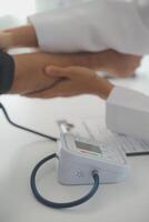 Male doctor uses a blood pressure monitor to check the body pressure and pulse of the patients who come to the hospital for check-ups, Medical treatment and health care concept. photo