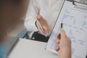 Close up view of job interview in office, focus on resume writing tips, employer reviewing good cv of prepared skilled applicant, recruiter considering application, hr manager making hiring decision photo