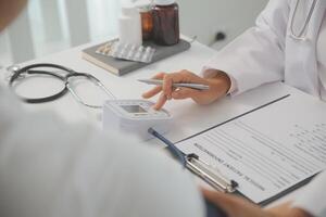 Male doctor uses a blood pressure monitor to check the body pressure and pulse of the patients who come to the hospital for check-ups, Medical treatment and health care concept. photo