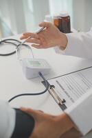 Male doctor uses a blood pressure monitor to check the body pressure and pulse of the patients who come to the hospital for check-ups, Medical treatment and health care concept. photo