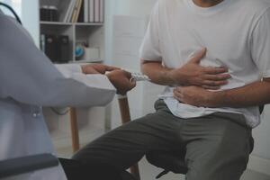 hombre sufrimiento con grave estómago dolor sentado a hogar. mano de maduro chico participación abdomen sufrimiento desde dolor, Diarrea o indigesto problema. caucásico chico prensado en barriga en doloroso sensación foto