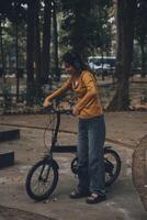 Happy young Asian woman while riding a bicycle in a city park. She smiled using the bicycle of transportation. Environmentally friendly concept. photo