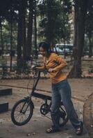 Happy young Asian woman while riding a bicycle in a city park. She smiled using the bicycle of transportation. Environmentally friendly concept. photo