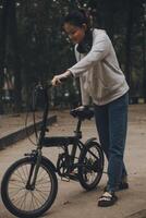 Happy Asian young woman walk and ride bicycle in park, street city her smiling using bike of transportation, ECO friendly, People lifestyle concept. photo