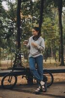 Happy Asian young woman walk and ride bicycle in park, street city her smiling using bike of transportation, ECO friendly, People lifestyle concept. photo