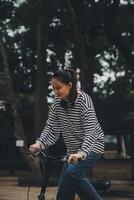 contento asiático joven mujer caminar y paseo bicicleta en parque, calle ciudad su sonriente utilizando bicicleta de transporte, eco amigable, personas estilo de vida concepto. foto