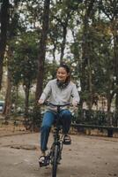 Happy Asian young woman walk and ride bicycle in park, street city her smiling using bike of transportation, ECO friendly, People lifestyle concept. photo