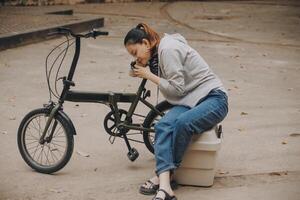 Happy Asian young woman walk and ride bicycle in park, street city her smiling using bike of transportation, ECO friendly, People lifestyle concept. photo