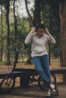 Happy Asian young woman walk and ride bicycle in park, street city her smiling using bike of transportation, ECO friendly, People lifestyle concept. photo