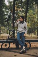 Happy Asian young woman walk and ride bicycle in park, street city her smiling using bike of transportation, ECO friendly, People lifestyle concept. photo