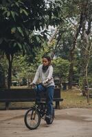 Happy Asian young woman walk and ride bicycle in park, street city her smiling using bike of transportation, ECO friendly, People lifestyle concept. photo