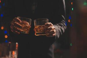 Celebration night, pour whiskey into a glass. Give to friends who come to celebrate photo