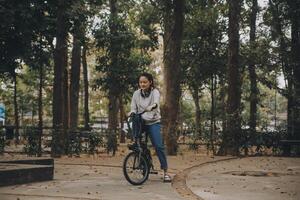 Happy Asian young woman walk and ride bicycle in park, street city her smiling using bike of transportation, ECO friendly, People lifestyle concept. photo