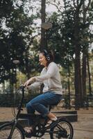 Happy Asian young woman walk and ride bicycle in park, street city her smiling using bike of transportation, ECO friendly, People lifestyle concept. photo