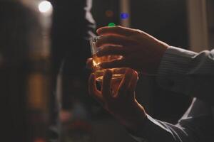 Celebration night, pour whiskey into a glass. Give to friends who come to celebrate photo