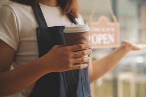 Startup successful small business owner sme beauty girl stand with tablet smartphone in coffee shop restaurant. Portrait of asian tan woman barista cafe owner. SME entrepreneur seller business concept photo