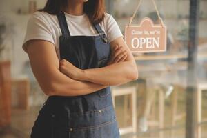 Startup successful small business owner sme beauty girl stand with tablet smartphone in coffee shop restaurant. Portrait of asian tan woman barista cafe owner. SME entrepreneur seller business concept photo