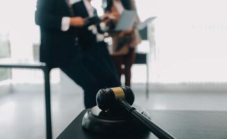 Justice and law concept.Male judge in a courtroom with the gavel, working with, computer and docking keyboard, eyeglasses, on table in morning light photo