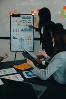 Business team meeting working with new startup project, discussion and analysis data the charts and graphs. Digital tablet, calculator, laptop computer using, Business finance and accounting concept. photo