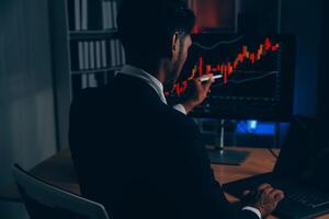 Thoughtful focused successful caucasian male stock investor, broker, financial adviser, sits at work desk, looks at computer, pensively analyze risks and prospects, rise or fall of cryptocurrency coin photo