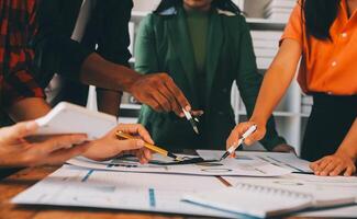 Male mature caucasian ceo businessman leader with diverse coworkers team, executive managers group at meeting. Multicultural professional businesspeople working together on research plan in boardroom. photo