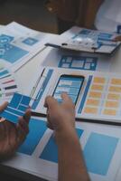 Close up ux developer and ui designer use augmented reality brainstorming about mobile app interface wireframe design on desk at modern office.Creative digital development agency photo