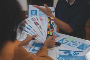 Close up ux developer and ui designer use augmented reality brainstorming about mobile app interface wireframe design on desk at modern office.Creative digital development agency photo