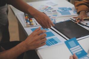 Close up ux developer and ui designer use augmented reality brainstorming about mobile app interface wireframe design on desk at modern office.Creative digital development agency photo