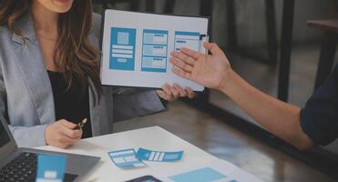 Close up ux developer and ui designer use augmented reality brainstorming about mobile app interface wireframe design on desk at modern office.Creative digital development agency photo